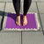 Woman standing on a purple and grey acupressure mat